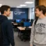 two students crossing paths at the door of a computer lab