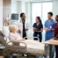 nursing students in hospital room with instructor and patient